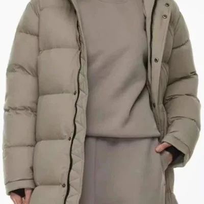 Taupe knee-length quilted puffer coat worn open over a matching sweatshirt, shown from the chest down