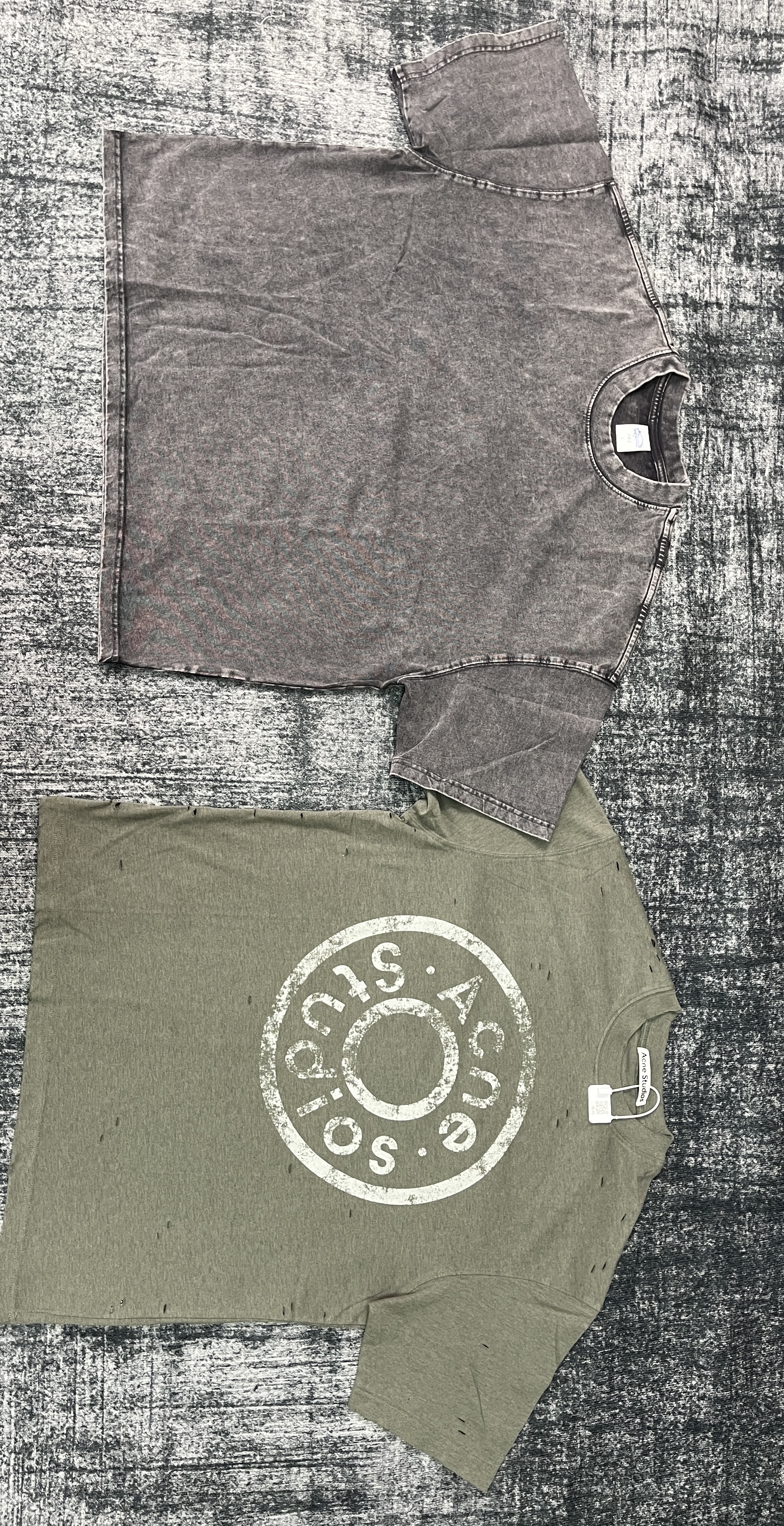 Two different T-shirts laid flat: a washed gray shirt at left and an olive printed shirt at right.
